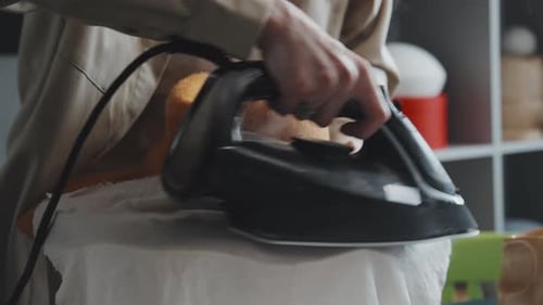 Person Steaming Hat with Iron and Cloth