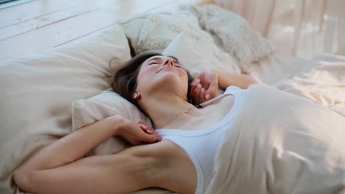 Brunette Enjoying Early Wakeup Stretching Arms on Comfortable Bed Closeup