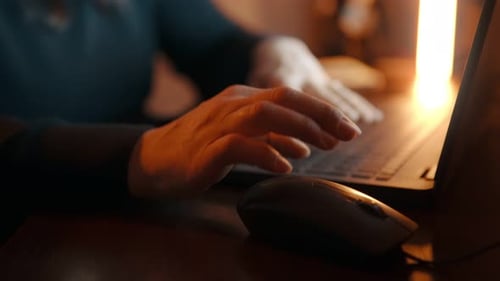 Die Hand der Frau bewegt die Maus und drückt die Finger auf der Laptop-Tastatur