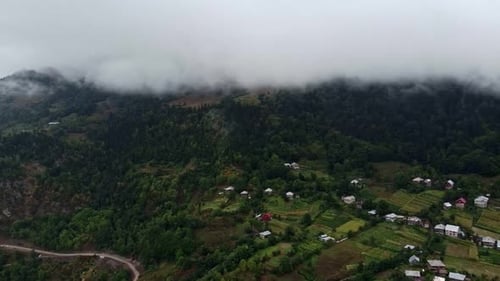a View of a Mountain with a Road Going Through It and a Few Houses on the Side of the Mountain