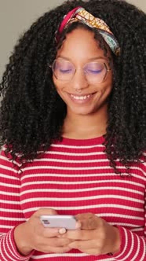 Smiling Woman Using Phone Indoors