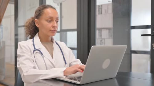 Multiracial Female Doctor Typing on Laptop