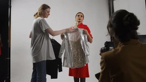 Model and Production Team in the Studio Stylist Chooses Jackets for Female Model Photographer Picks