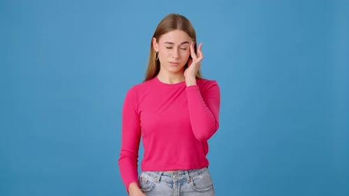 Young Woman Suffering from Headache in Studio