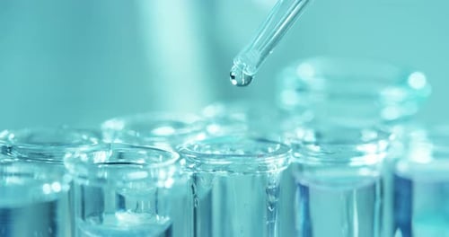 Close Up of Pipette Dripping Liquid into Test Tube