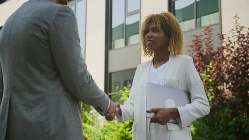 Businesswoman and Businessman Greeting Handshake Outdoors