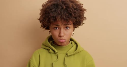 Gloomy Unhappy Displeased Afro American Woman Purses Lips and Looks Frustrated At
