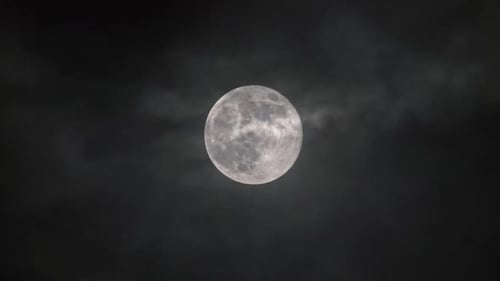 Full Moon Ascending in a Cloudy Night Sky