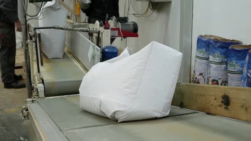 Bag of feed on the conveyor belt moves forward