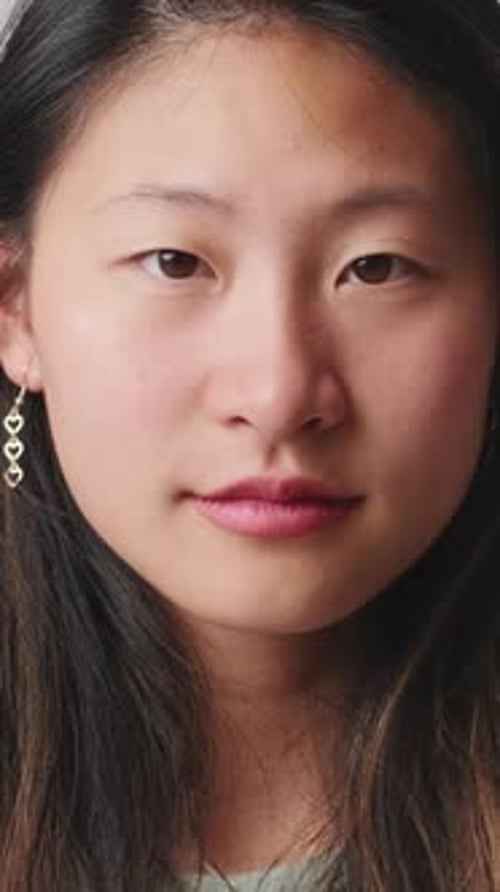 Close up, young woman looking at camera isolated over white background in studio