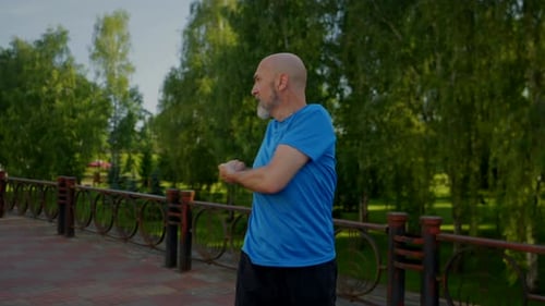Mature Man Stretching in Urban Park on Sunny Day