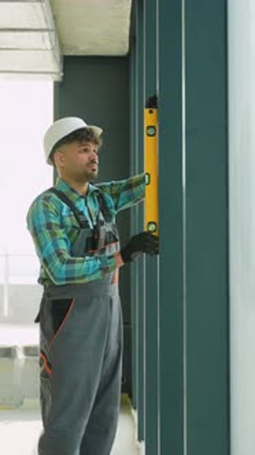 Construction Worker Uses Building Level Inside Building