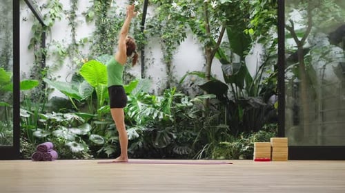 Woman in focused twisting pose in modern studio