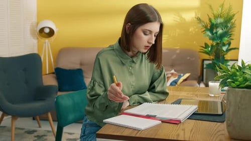 Woman Studying and Taking Notes at Home