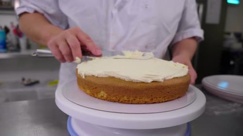 Woman Decorating Cake with Frosting in Kitchen