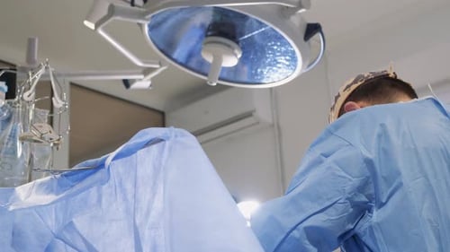 The Process of the Surgeon's Work in the Operating Room He Performs an Operation on the Legs