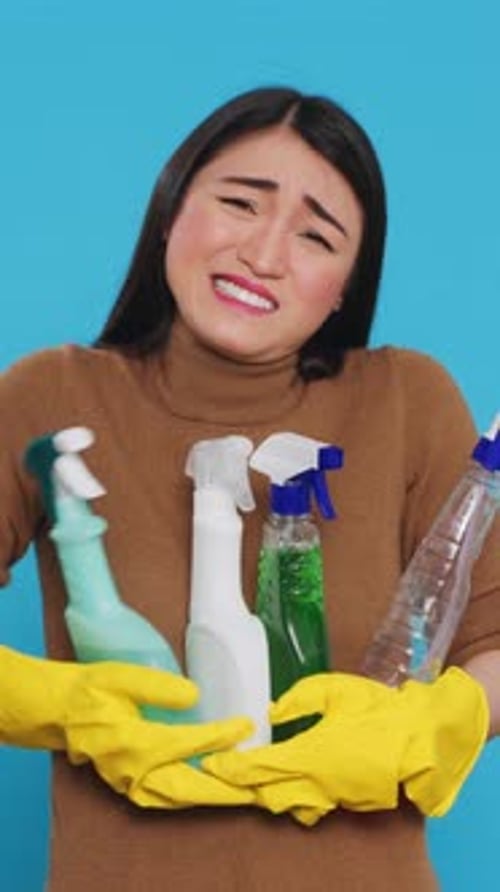 Vertical Video Overwhelmed Tired Housekeeper Wearing Gloves While Holding Multiple Sanitary