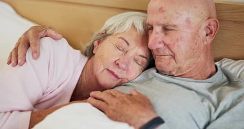Affectionate Senior Couple Cuddling in Bed at Home