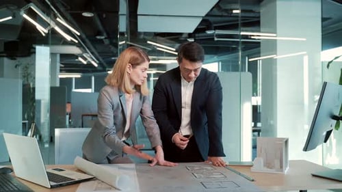 Architects Collaborate Over Blueprints in Modern Office