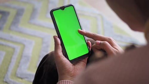 Rear View of Women Using Smart Phone with Green Screen Sitting on Sofa