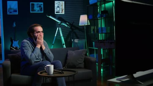 Man Watching Sports Game Reacts With Loss