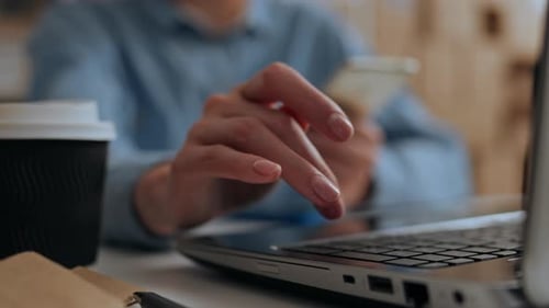 Warehouse Manager Worker Works At A Laptop Laptop Against The Background Of Boxes Of Cardboard Cargo
