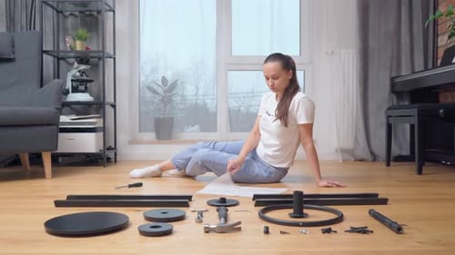 Une femme consulte les instructions avant de commencer à assembler les meubles.