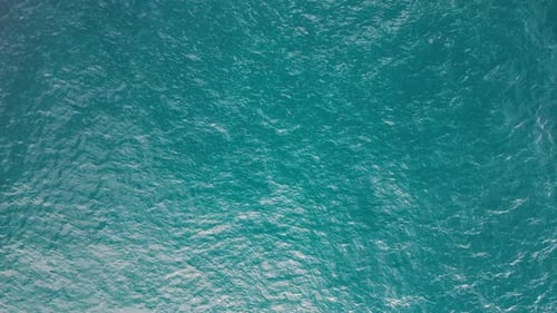 Die von oben nach unten gerichtete Luftbildkamera an der Meeresoberfläche fliegt mit Wellen und Wellen über die Wasseroberfläche