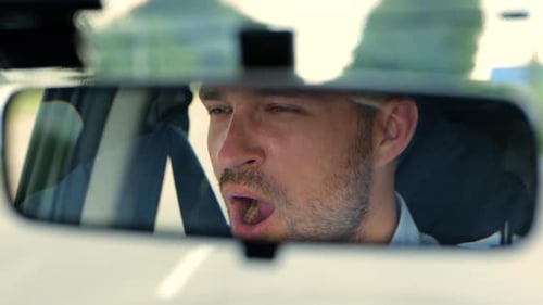 Close Up of Young Tired Man Inside the Car