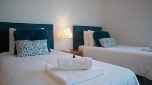 Traditional Hotel Bedroom with White Clean Bedding and Towels for Vacationers