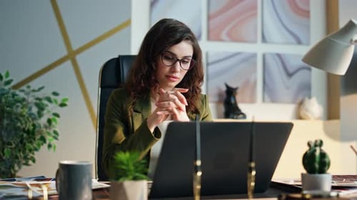 Sad young business woman receives bad news at laptop in modern office