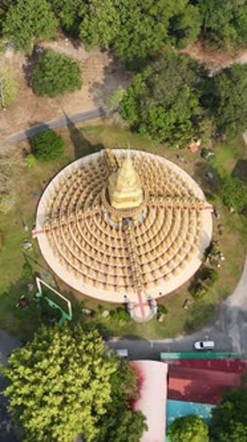 Inclinaison aérienne verticale au-dessus de la pagode dorée Chedi 500 Yot à Wat Pa Sawang Bun, révélant