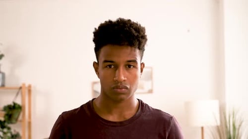 Young Man Smiling at Camera in Bright Room