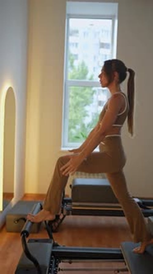 Woman doing Pilates on Pilates machine in studio