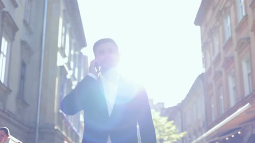 Portrait of Serious Caucasian Male Professional Standing in City and Talking on Smartphone Handsome
