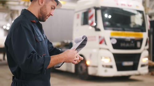 Male worker is in the modern warehouse or manufacturing company.