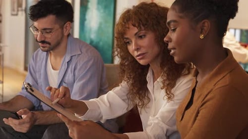 Une équipe commerciale diversifiée collabore sur un projet avec une tablette