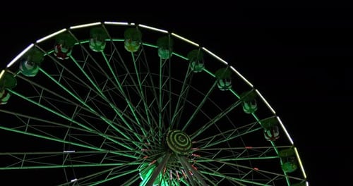 Nighttime ferris wheel experience amusement park urban aerial view vibrant lights