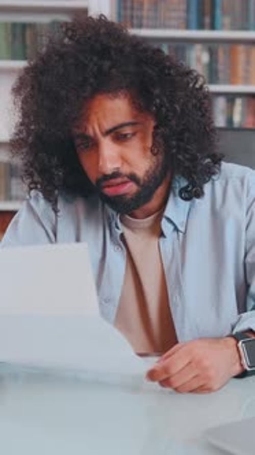 A Young Man Deeply Focuses on a Letter in a Cozy Reading Nook