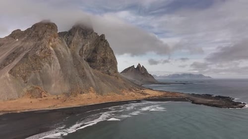 Majestic Vestrahorn mountains & black sand coastline - aerial view of Iceland’s rugged beauty