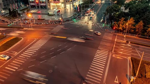 Night overhead of busy intersection traffic at night with cars, trucks, buses and trains