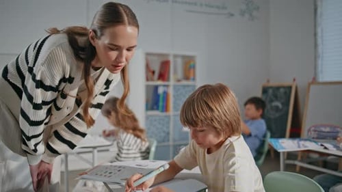 Teacher Assisting Young Student in Classroom
