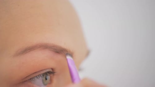 Closeup of a Woman Darkening Her Eyebrows with Makeup