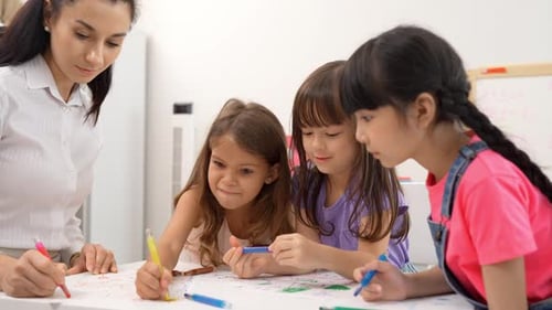 Children Draw Together With Teacher in Bright Classroom