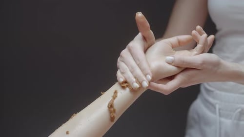 Woman Enjoying a Sugar Sea Salt Natural Body Scrub Exfoliation Treatment with Professional