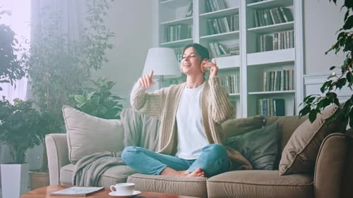 Woman Listening to Music Indoors on Couch