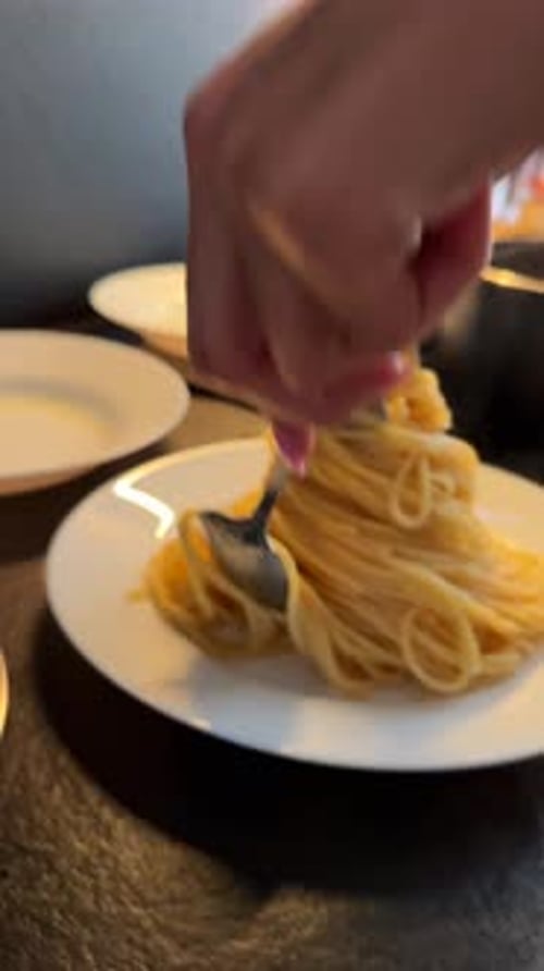 Plating Hot Pasta with Tongs in the Kitchen