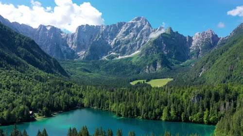 Picturesque lake Lago Fusine in Italy. Fusine lake with Mangart peak on background. Popular travel d