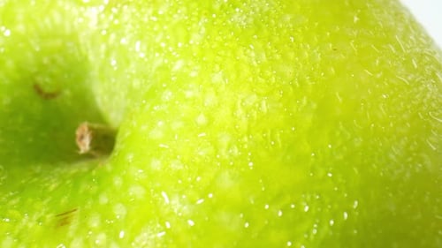 A green apple with droplets of water. macro video.