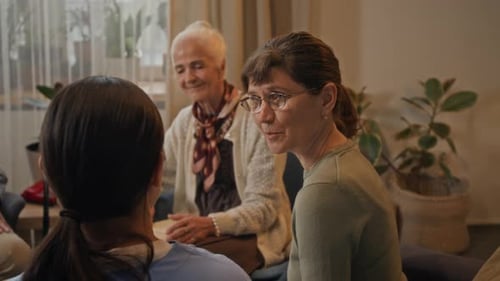 Three women talking in living room, close